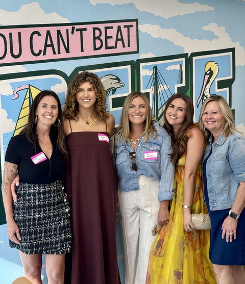 Julie Bowman with four other women in front of the You Can&rsquo;t Beat St. Pete mural, all wearing name tags.
